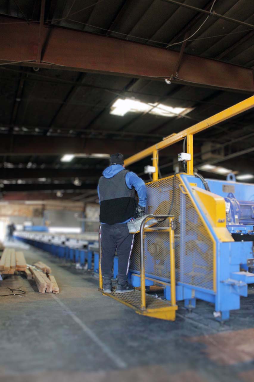 a worker operating a machine to make trusses for houses in Utah